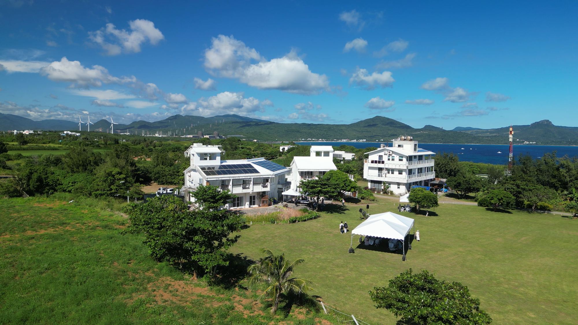 空拍卡米克,白屋與草原上的白色帳篷,遠方是海灣與山